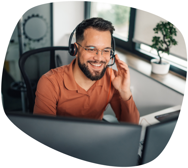 Terra Assistência Técnica homem branco com barba usando óculos e headphones em frente ao computador